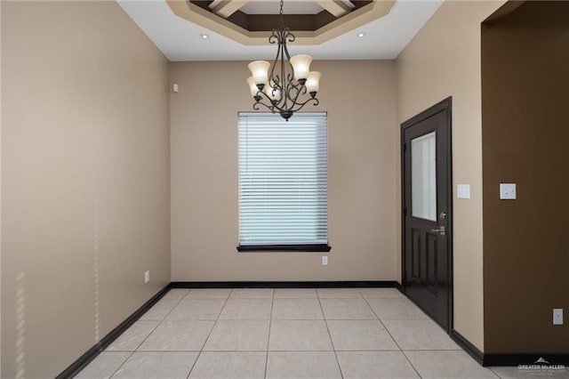 unfurnished room featuring a raised ceiling, light tile patterned floors, and an inviting chandelier