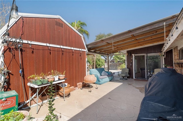 view of patio featuring an outbuilding, a grill, and fence