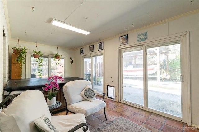 sitting room with tile patterned flooring and crown molding