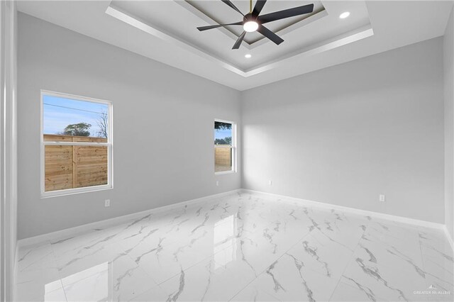 spare room featuring a healthy amount of sunlight and baseboards