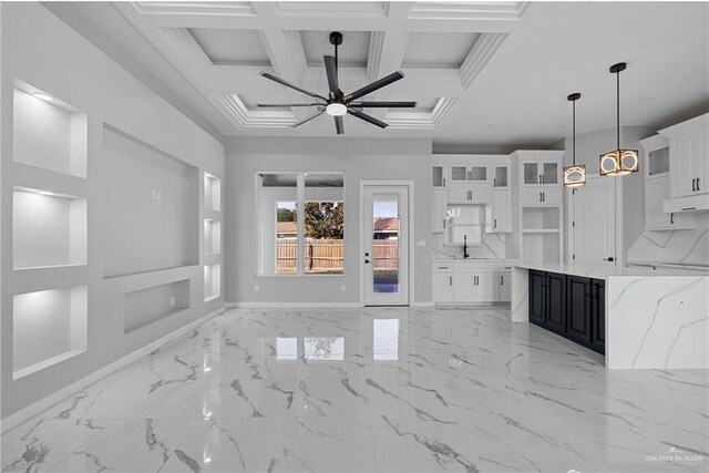 interior space with a sink, coffered ceiling, baseboards, beam ceiling, and a ceiling fan
