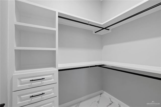 walk in closet with marble finish floor