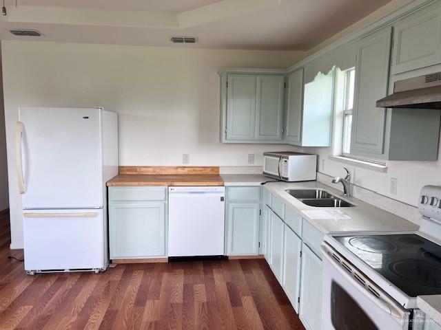 1056 E Mile 11 N, Weslaco, TX 78599 - kitchen with white appliances, under cabinet range hood, light countertops, and dark wood-style flooring