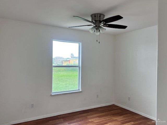 1056 E Mile 11 N, Weslaco, TX 78599 - unfurnished room with plenty of natural light, wood finished floors, and ceiling fan