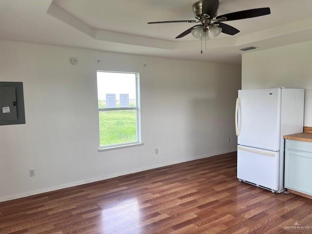 1056 E Mile 11 N, Weslaco, TX 78599 - kitchen featuring freestanding refrigerator, electric panel, wood finished floors, ceiling fan, and white cabinets