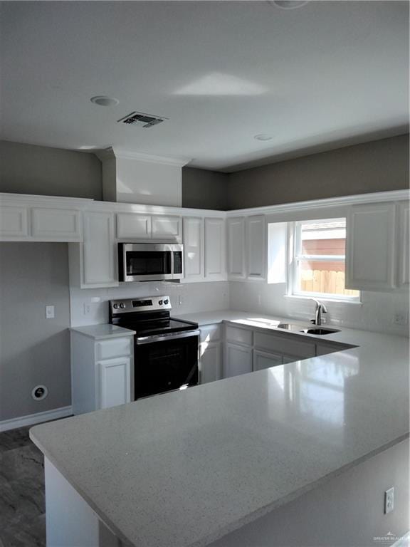 3018 Greenwood Dr, Corpus Christi, TX 78405 - kitchen with stainless steel appliances, a sink, visible vents, white cabinets, and a peninsula