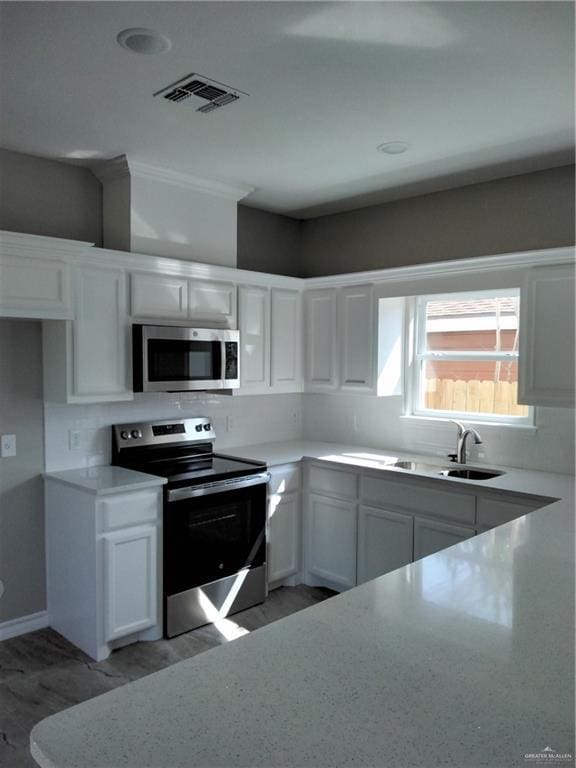 3018 Greenwood Dr, Corpus Christi, TX 78405 - kitchen featuring visible vents, white cabinets, a sink, and stainless steel appliances