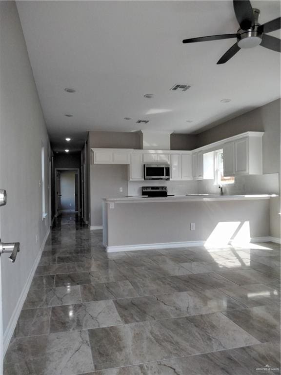 3018 Greenwood Dr, Corpus Christi, TX 78405 - kitchen with marble finish floor, visible vents, white cabinetry, and stainless steel microwave