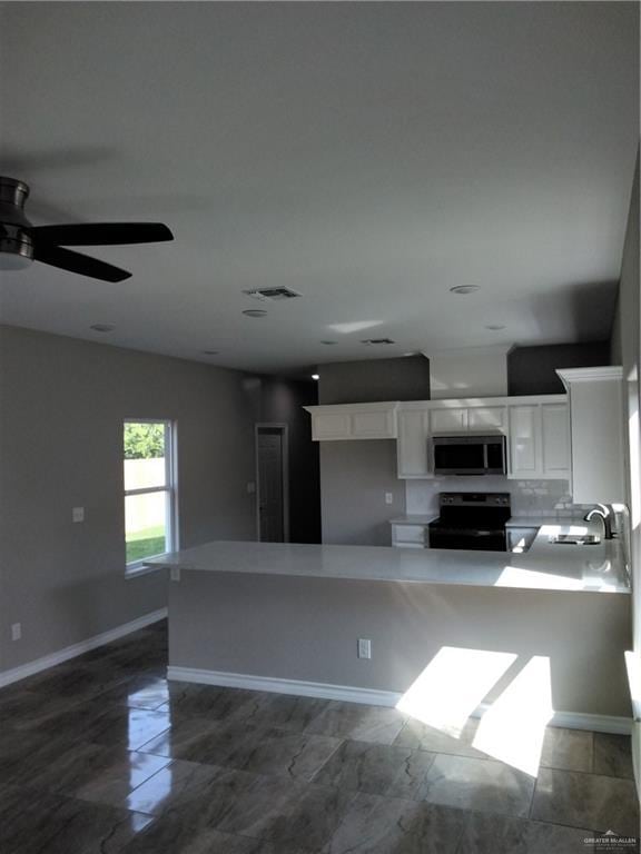 3018 Greenwood Dr, Corpus Christi, TX 78405 - kitchen featuring ceiling fan, stainless steel microwave, white cabinetry, a sink, and range with electric cooktop