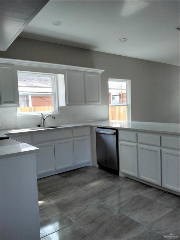 3018 Greenwood Dr, Corpus Christi, TX 78405 - kitchen featuring white cabinetry, light countertops, tasteful backsplash, and stainless steel dishwasher