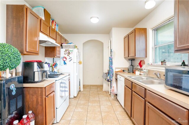 3292 Turquia St, Brownsville, TX 78520 - kitchen featuring arched walkways, a sink, light countertops, white appliances, and light tile patterned flooring