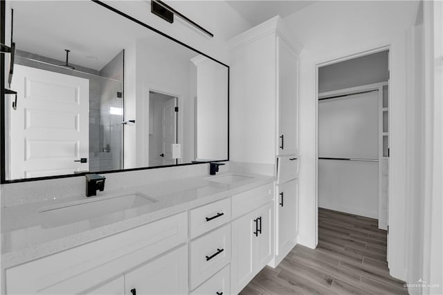 bathroom featuring hardwood / wood-style floors, vanity, and walk in shower