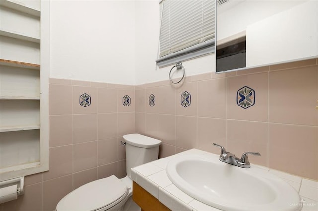 bathroom with vanity, tile walls, and toilet