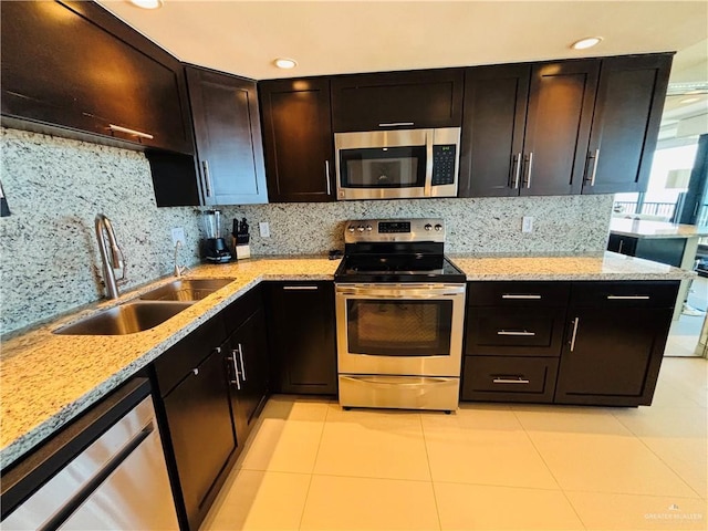 2100 Gulf Blvd, South Padre Island, TX 78597 - kitchen featuring stainless steel appliances, light stone countertops, tasteful backsplash, light tile patterned floors, and recessed lighting