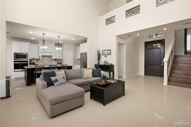 2509 Mcleod Ave, Edinburg, TX 78539 - living room featuring light tile patterned floors, stairs, recessed lighting, baseboards, and a towering ceiling