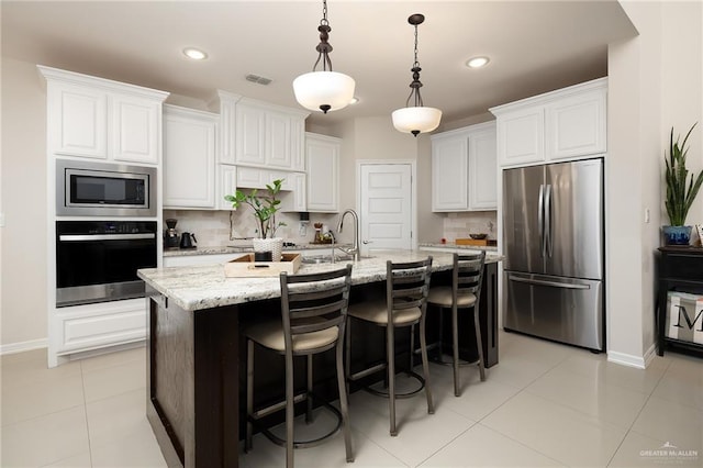 2509 Mcleod Ave, Edinburg, TX 78539 - kitchen featuring appliances with stainless steel finishes, tasteful backsplash, a sink, white cabinets, and recessed lighting