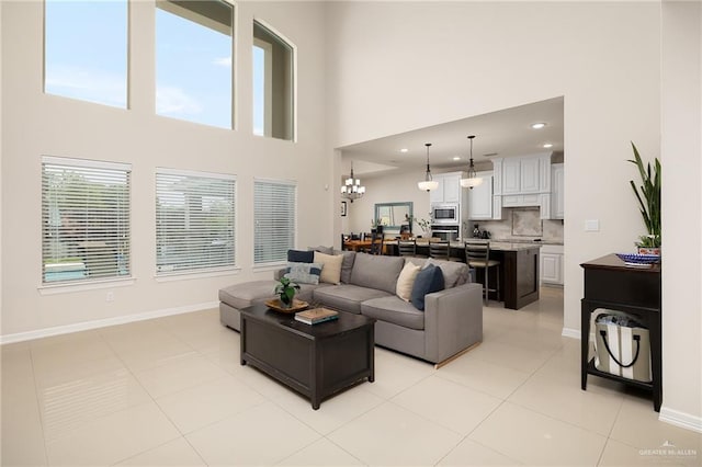 2509 Mcleod Ave, Edinburg, TX 78539 - living area featuring a towering ceiling, baseboards, light tile patterned flooring, and a chandelier