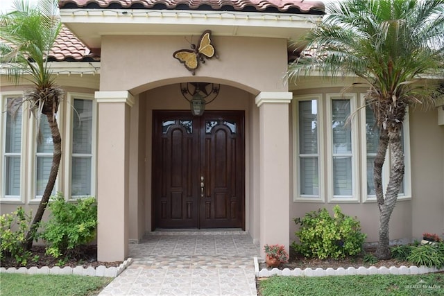 2707 Live Oak St, Mission, TX 78574 - view of exterior entry with stucco siding and a tile roof