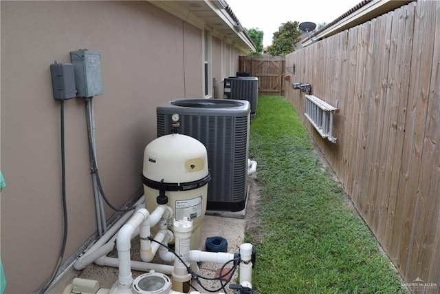 2707 Live Oak St, Mission, TX 78574 - exterior view of central AC unit, stucco siding, pump, and a satellite dish