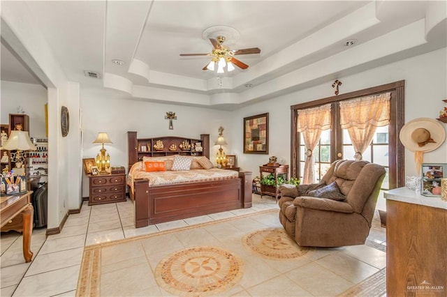 tiled bedroom featuring a raised ceiling and ceiling fan