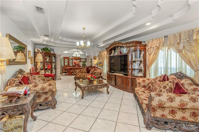 living room with a chandelier, light tile patterned floors, and a tray ceiling