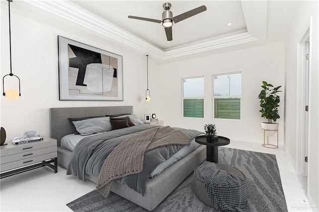 bedroom with ceiling fan and a tray ceiling