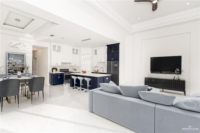 living room with ceiling fan, crown molding, and sink