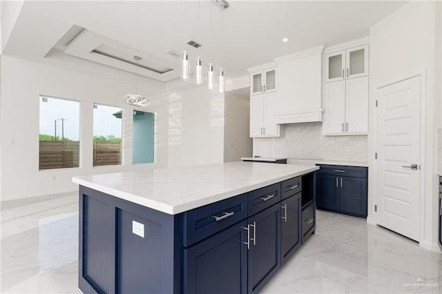 kitchen featuring white cabinetry, hanging light fixtures, tasteful backsplash, blue cabinets, and a kitchen island