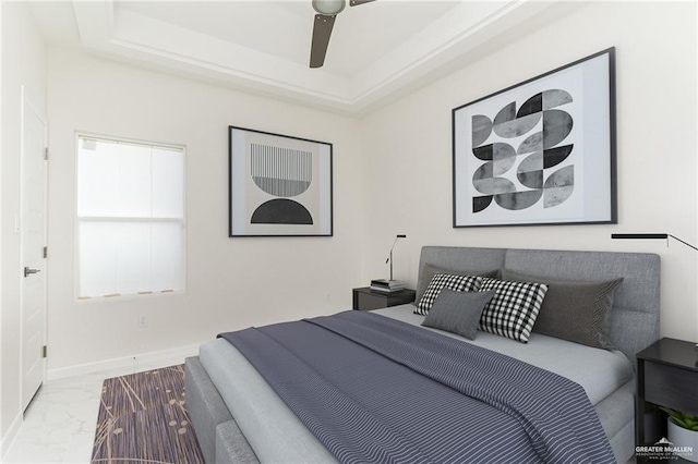 bedroom with a tray ceiling and ceiling fan