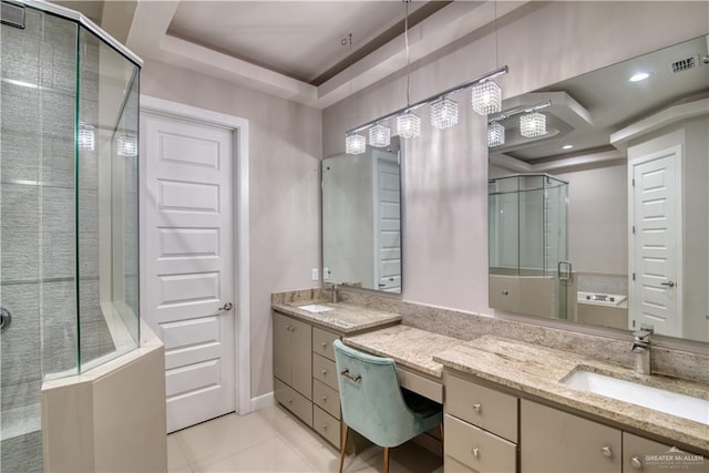 bathroom featuring tile patterned flooring, vanity, a raised ceiling, and walk in shower