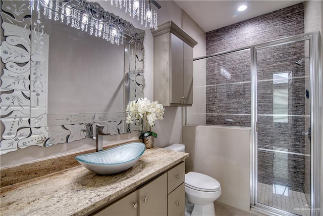 bathroom featuring tile patterned floors, vanity, toilet, and an enclosed shower