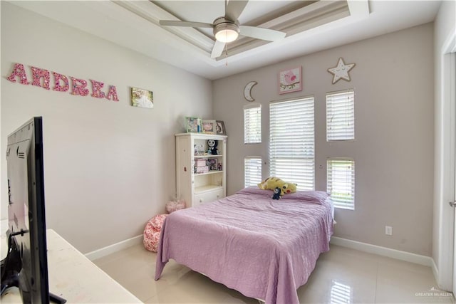 bedroom with ceiling fan and a tray ceiling