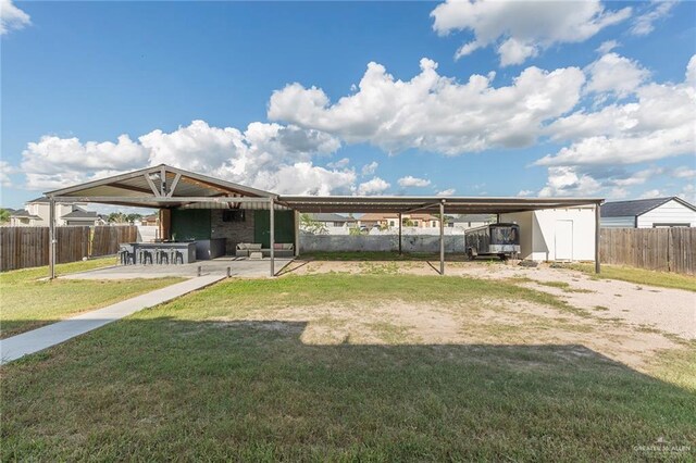 back of house featuring a lawn and an outdoor structure