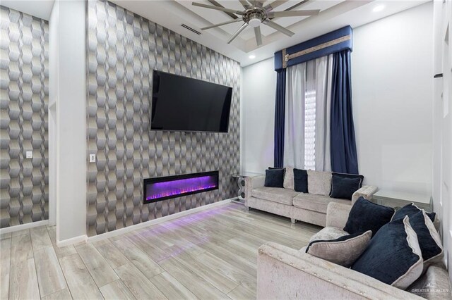 living room featuring ceiling fan, a fireplace, and hardwood / wood-style flooring