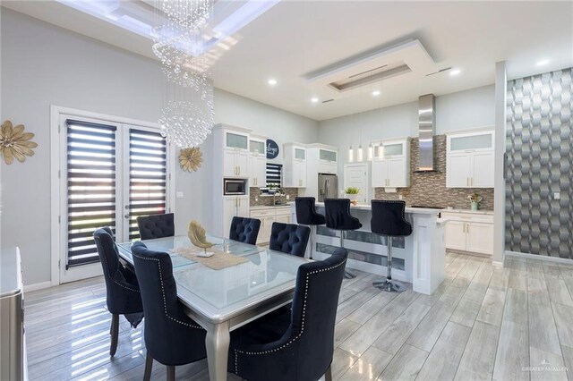 dining space with light wood-type flooring and an inviting chandelier