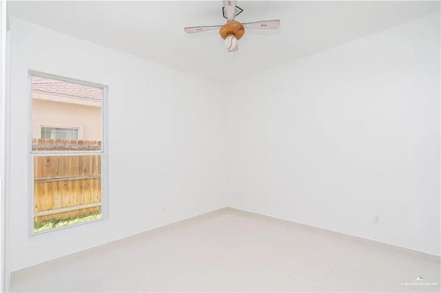 empty room with ceiling fan and tile patterned flooring