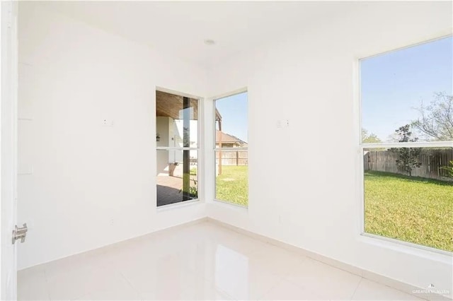 tiled spare room with plenty of natural light