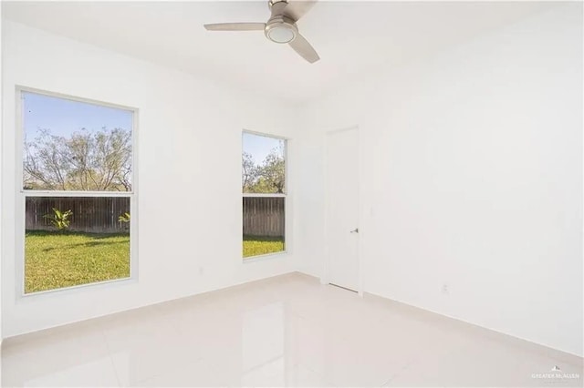 tiled spare room featuring ceiling fan