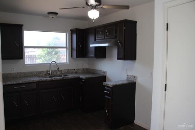 kitchen with stone countertops, ceiling fan, and sink