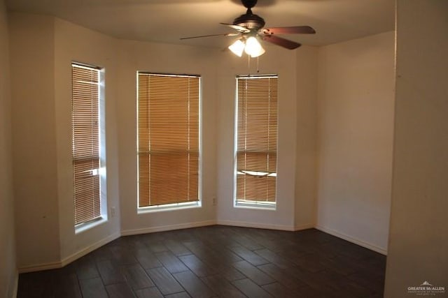 empty room with ceiling fan and dark hardwood / wood-style floors