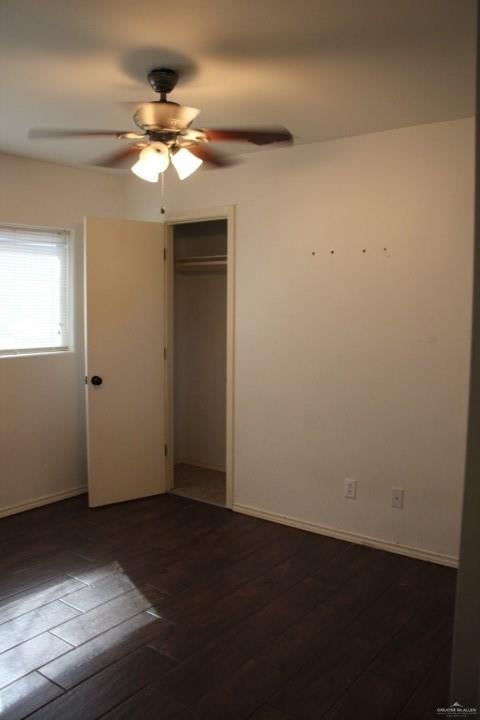 unfurnished bedroom featuring a closet, ceiling fan, and dark wood-type flooring