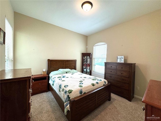 bedroom with light carpet and lofted ceiling