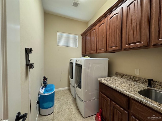 laundry area featuring washer and dryer, cabinets, light tile patterned floors, and sink