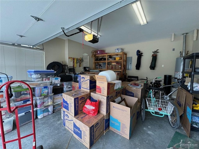 garage with electric panel, a garage door opener, and gas water heater