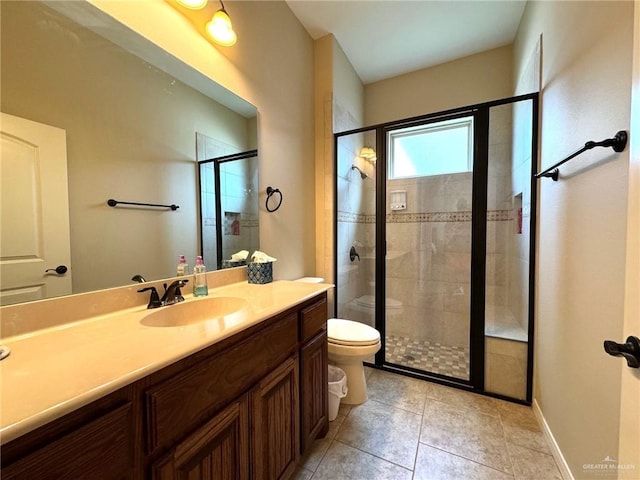 bathroom with tile patterned flooring, vanity, a shower with door, and toilet