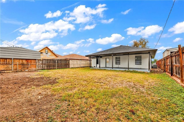 back of property with a patio area and a lawn