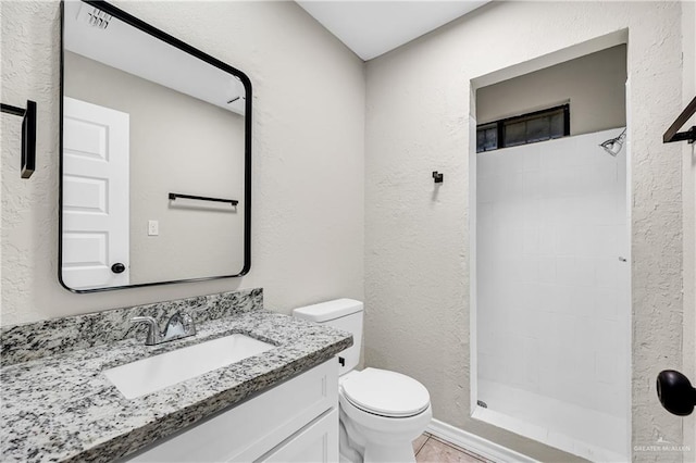 bathroom featuring toilet, walk in shower, and vanity