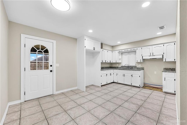 kitchen featuring white cabinets, sink, and light tile patterned flooring