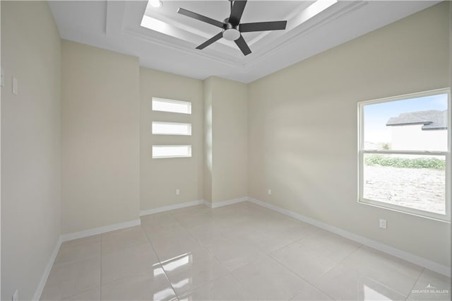 spare room featuring ceiling fan, baseboards, a raised ceiling, and light tile patterned flooring