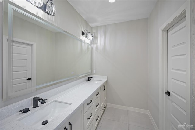 bathroom featuring baseboards, double vanity, a sink, and tile patterned floors